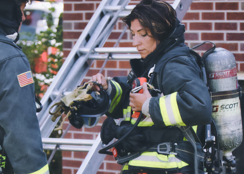 Female firefighter gearing up